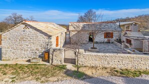 A stone building with a traditional design, featuring a central courtyard and a small tree. - Ranch Wild North (Benkovac)