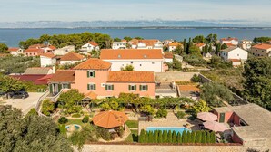Zona residencial costera con casas, piscina y vista al mar.