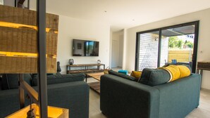 A modern living room with a sofa, coffee table, and a flat-screen TV mounted on the wall. - Modern house with great facilities and a large jacuzzi (Crozon)
