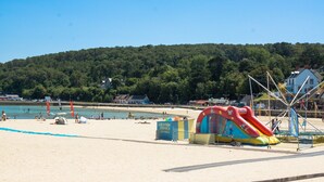A beach with a large inflatable slide, tents, and a location sign. - Modern house with great facilities and a large jacuzzi (Crozon)