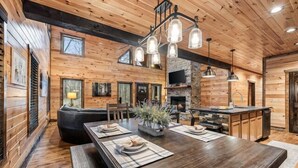Interior de madera con una mesa de comedor para cuatro, una chimenea y una pared de acento de piedra.