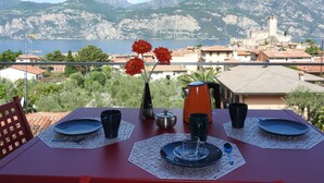A table set for two with a view of a coastal town and mountains.