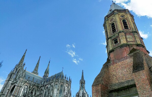 A historic church with a prominent clock tower and intricate spires.