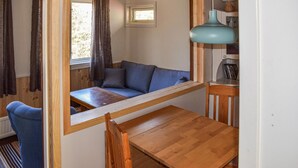 A room with a wooden bench, a blue sofa, a table, and a lamp. - Gorgeous home in Mollaryd with WiFi (Mollaryd)