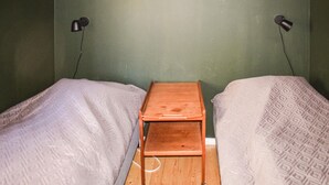 A single bed with a wooden nightstand in a room with green walls and two wall-mounted lamps. - Gorgeous home in Mollaryd with WiFi (Mollaryd)