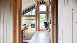 Een houten interieur met een eethoek, een bank en uitzicht op de omgeving.
