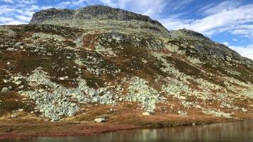 A mountainous landscape with a lake in the foreground and a clear sky above.