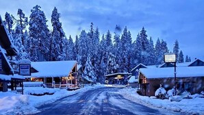 Une route enneigée mène à un bâtiment sur lequel est apposée une enseigne indiquant « CENTRE D’EXCURSIONS ET DE RANDÉES ».