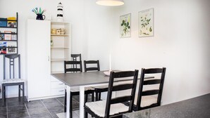 A dining area with a table and chairs, a white cabinet with shelves, and two botanical prints on the wall. - Stunning home in Skillinge with WiFi (Skillinge)