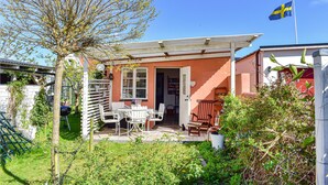 A small house with a patio, a flag, and a garden. - Stunning home in Skillinge with WiFi (Skillinge)