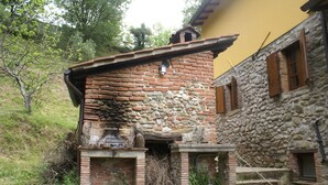 A rustic building with a stone facade and a brick chimney. - Tuscan tradition renovated in 2021 (Barga)