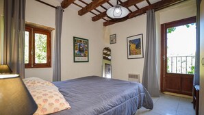 A bedroom with a bed, a lamp, a window, and a door leading to a balcony. - Gorgeous apartment in CARCHETO BRUSTICO (CARCHETO BRUSTICO)