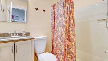 Une salle de bain comprenant des toilettes, un lavabo et une douche.