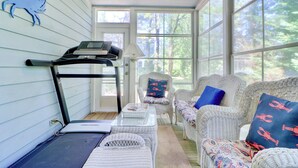 A sunroom with a treadmill, wicker furniture, and large windows. - ONLY A 7 MINUTE WALK TO THE BEACH! (Bethany Beach)