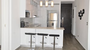 Eine moderne Küche mit einer zentralen Kochinsel, Edelstahlgeräten und einer Bar mit Sitzplätzen.