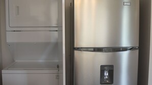 Eine kleine Küche mit Einbauofen und Edelstahl-Kühlschrank.