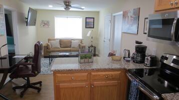 A modern kitchen with granite countertops, wooden cabinets, and stainless steel appliances.