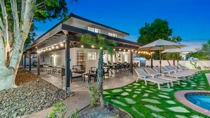A covered patio with outdoor seating and a pool area. - Large Home 12 beds Gameroom Heated Salt Pool PPG (Palm Desert)