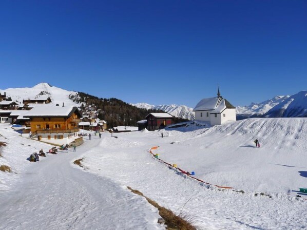 A snow-covered mountain village with wooden buildings and a church. - Huwetz 2. OG Süd by Interhome (Bettmeralp)