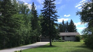 A residential property with a single-story house, a driveway, and a well-maintained lawn. - Enjoy Northern MN (Cook)
