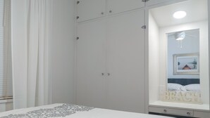 A bedroom with a bed, a wardrobe, a mirror, and a window with curtains. - Huge historic on Lake Michigan w/ large yard, fire pit, BBQ & air conditioning (Manistee)