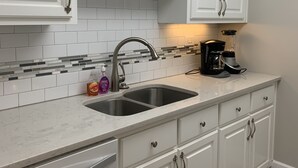 A kitchen with white cabinets, a double sink, and a coffee maker on the counter. - Cozy place in heart of Atlanta  (Atlanta)