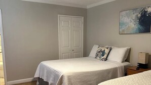 A bedroom with two beds, a ceiling fan, a door, and a painting on the wall. - Cozy place in heart of Atlanta  (Atlanta)