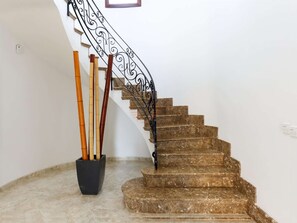 A marble staircase with a black wrought iron railing, leading to a landing. - Villa Llac Blau – Family, pool & beach Alcudia (Puerto de Alcudia)