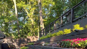A landscaped garden with tiered flower beds and a patio area with outdoor furniture. - LOCATION - DUNWOODY; NEW-BEAUTIFUL MODERN HOUSE & Outdoor Seasonal Private Pool (Atlanta)