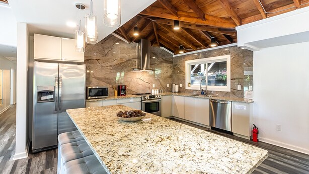 A modern kitchen with a large island, stainless steel appliances, and a stone backsplash. - LOCATION - DUNWOODY; NEW-BEAUTIFUL MODERN HOUSE & Outdoor Seasonal Private Pool (Atlanta)