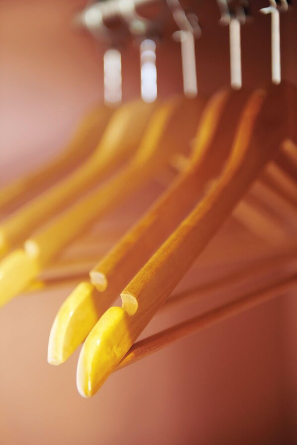 A close-up of wooden hangers with yellow handles.