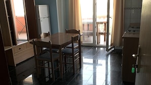 A dining area with a table and chairs, a refrigerator, and a sliding glass door leading to an outdoor patio. - Villa ata Razanac - Apartment With sea View (Razanac)