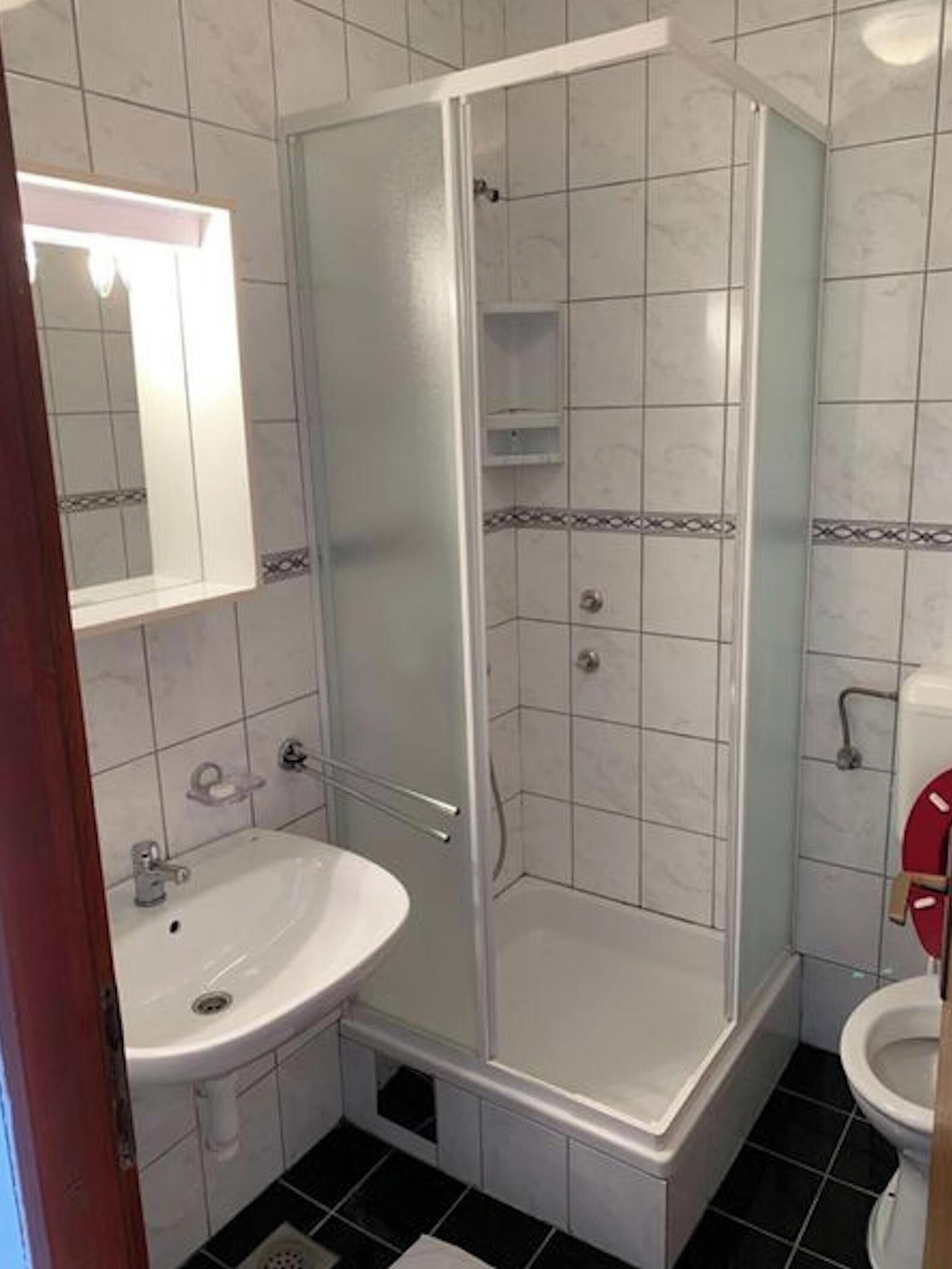 A bathroom with a shower, sink, and toilet.