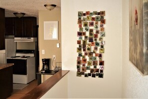 A kitchen with dark wooden cabinets, a stainless steel range hood, a white stove, and a wall-mounted coffee maker. - Urbana the Charming Well-lit two Bedrooms Apartment (Grand Forks)