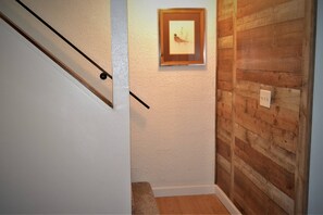 A staircase with a wooden handrail, a framed picture on the wall, and a wooden panel wall.