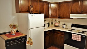 A kitchen with wooden cabinets, a white refrigerator, a dishwasher, an oven, and a microwave. - Arhaus 3 Serene Two-bedroom Retreat (Grand Forks)