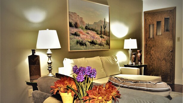A living room with a sofa, two lamps, a painting, and two flower vases on a table. - Arhaus 3 Serene Two-bedroom Retreat (Grand Forks)