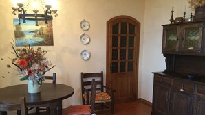 Ein Essbereich mit einem runden Tisch, Stühlen, einem Blumenstrauß und einem Gemälde an der Wand.
