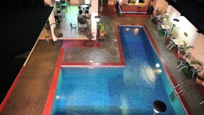 A pool area with two pools, lounge chairs, and tables. - Room-best Western Plus-presidential Suit (Ibadan)