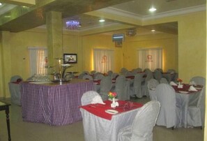 A conference room with tables and chairs, a podium, and a television screen. - Room-abuja Elomaz Hotel-guest Suite (Abuja)
