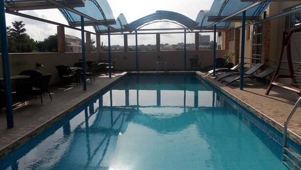 Une piscine dotée de parasols, de chaises longues et de tables.