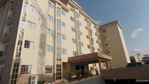 Un hôtel à plusieurs étages, doté d’une façade sobre, de grandes fenêtres et d’un espace d’entrée abrité.