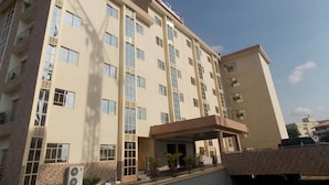 A multi-story hotel with a flat facade, large windows, and a covered entrance area. - Room-ayalla Hotel-superior Deluxe (Port Harcourt)