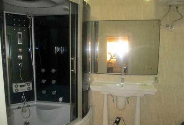 A bathroom with a bathtub, a sink, and a mirror.