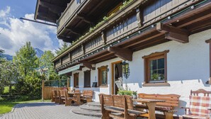 A traditional chalet with outdoor seating and a mountain backdrop. - Holiday home on a former stables (Brixen im Thale)