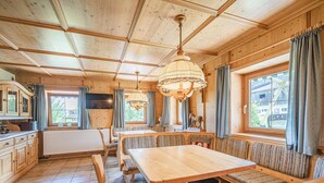 A wooden cabin interior with a dining area, seating, and a television. - Holiday home on a former stables (Brixen im Thale)