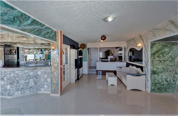 A modern interior with a bar area, kitchen, and seating space. - Magnificent View nice double room with shared pool and Ac (Piskopiano)