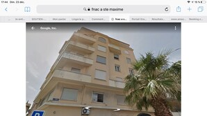 Ein mehrgeschossiges Gebäude mit einem Parterre-Salon und einem sichtbaren Parkplatzschild.