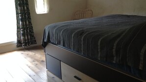 Une chambre à coucher avec un lit, une fenêtre et une petite fenêtre.