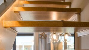 Una escalera moderna con escalones de madera y barandilla blanca.